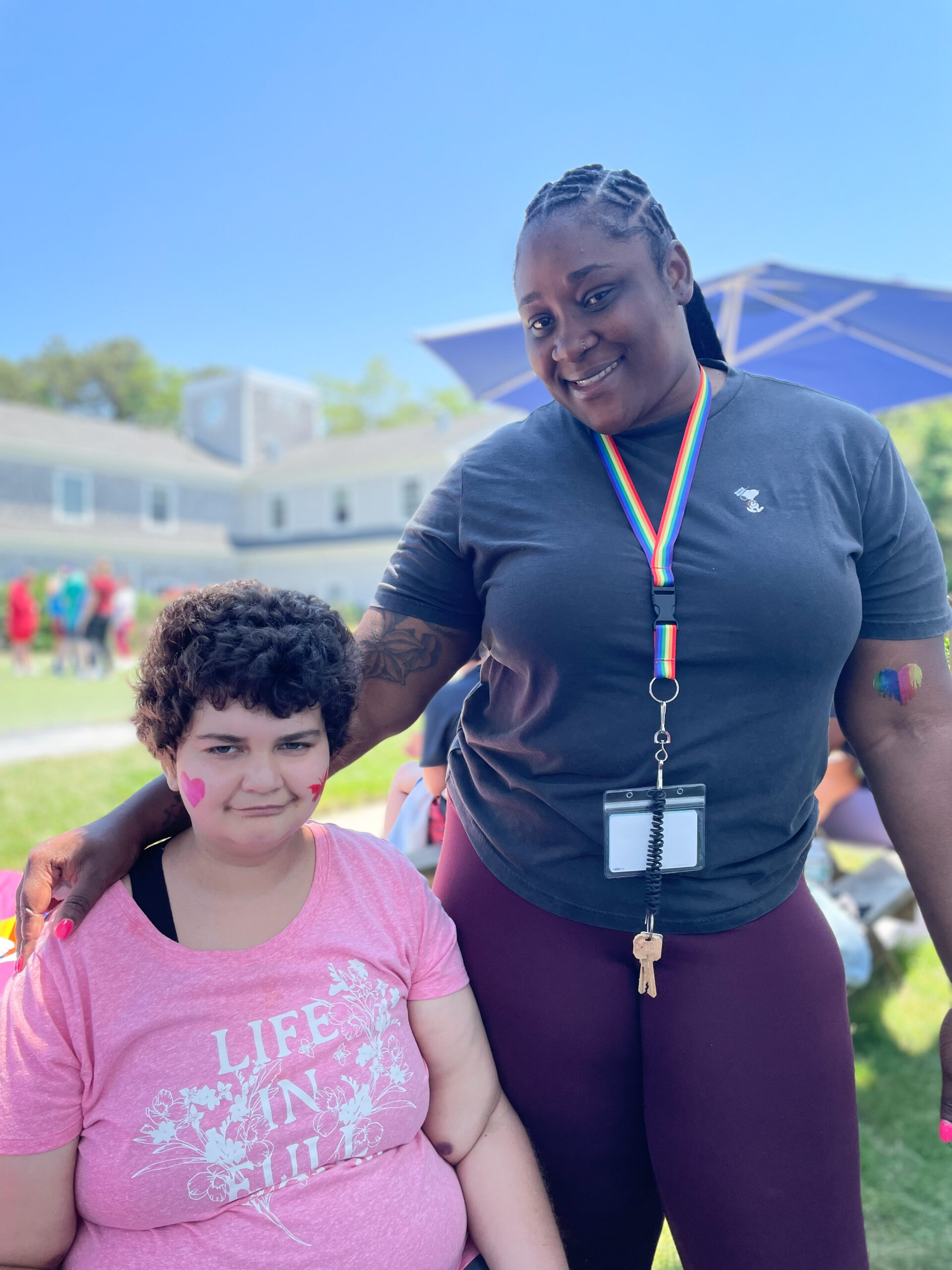 Woman standing with her arm around a younger girl. 